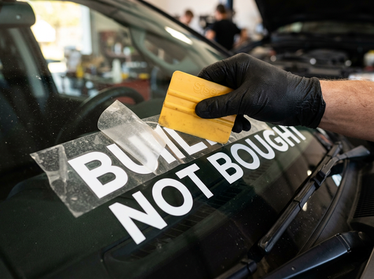 Vinyl windshield banner install close-up with squeegee showing crisp cut vinyl edges
